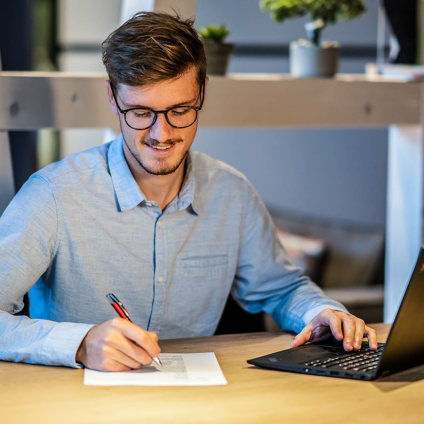 Mann mit Laptop am Schreibtisch