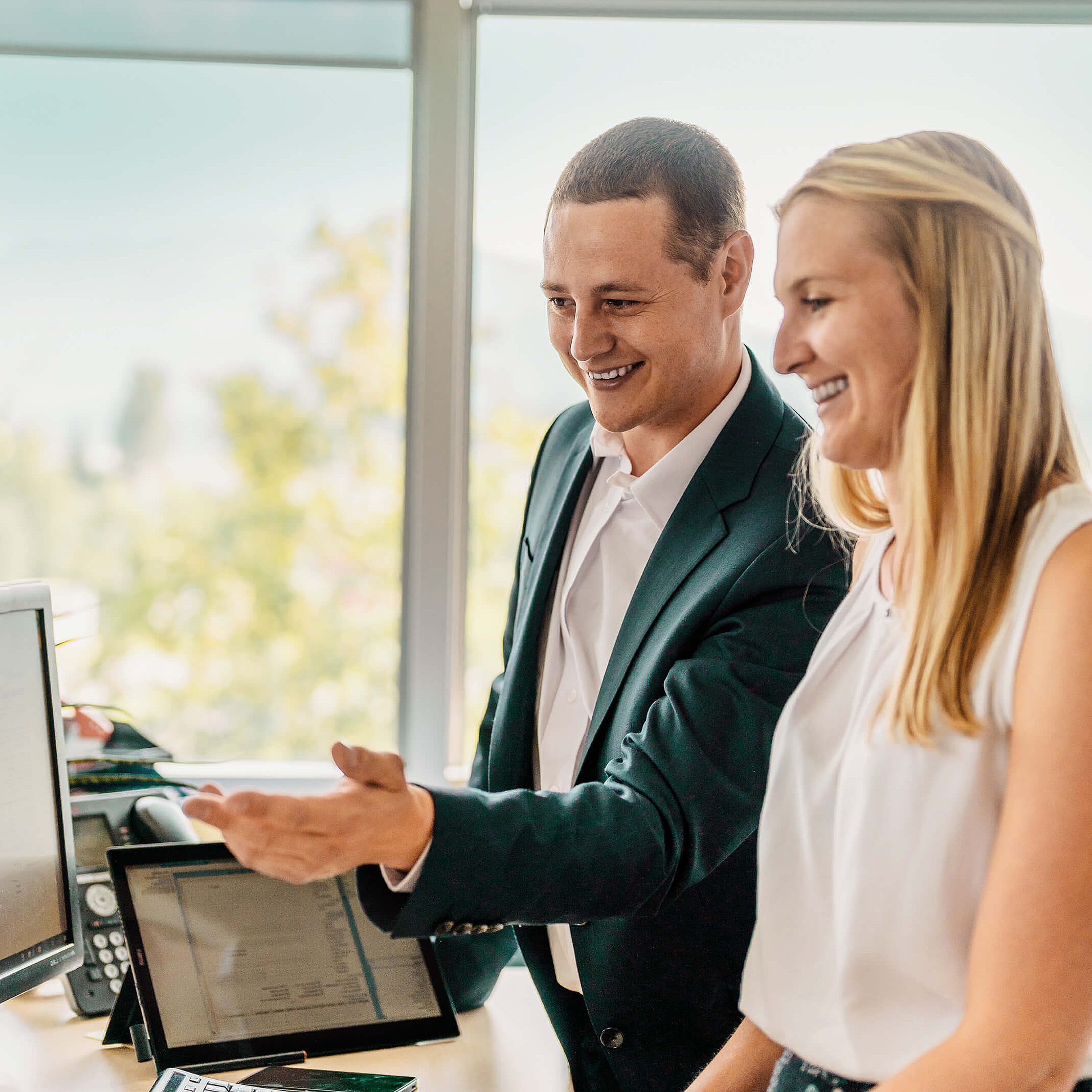 Frau und Mann stehen vor Computer