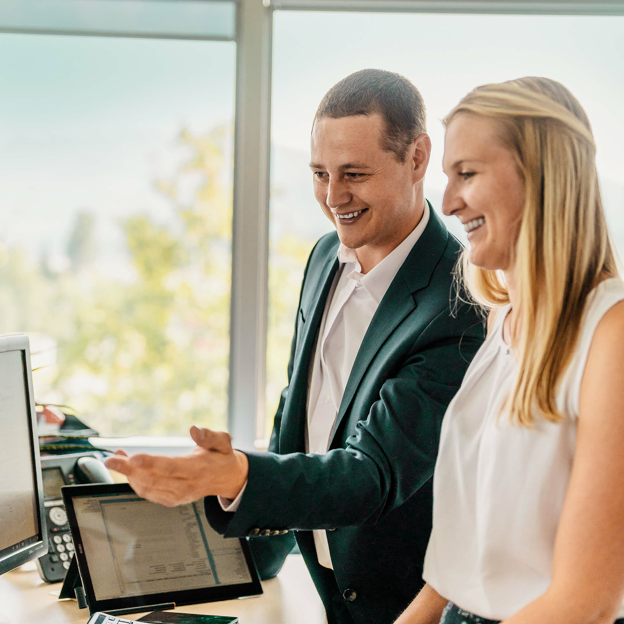 Frau und Mann stehen vor Computer