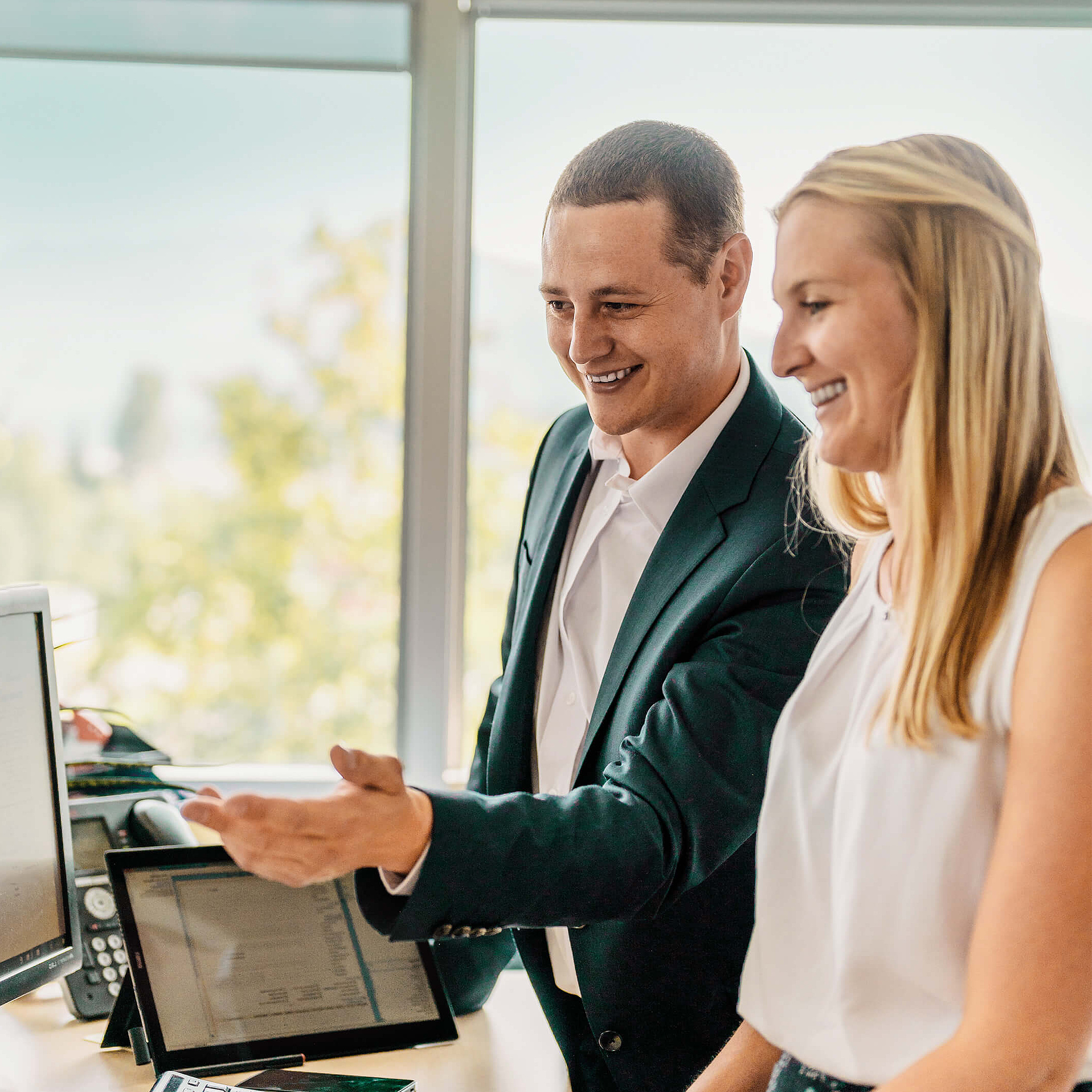 Frau und Mann stehen vor Computer