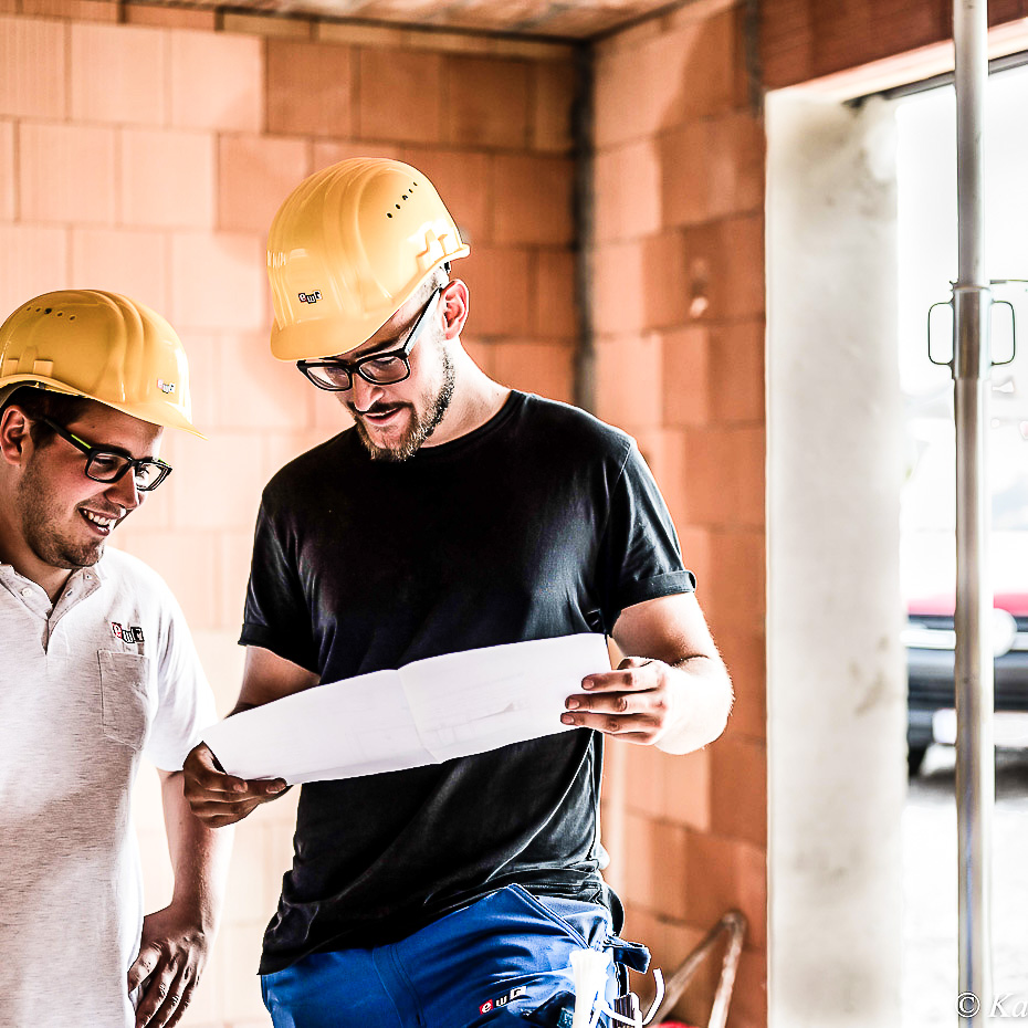 Arbeiter besprechen Plan auf Baustelle