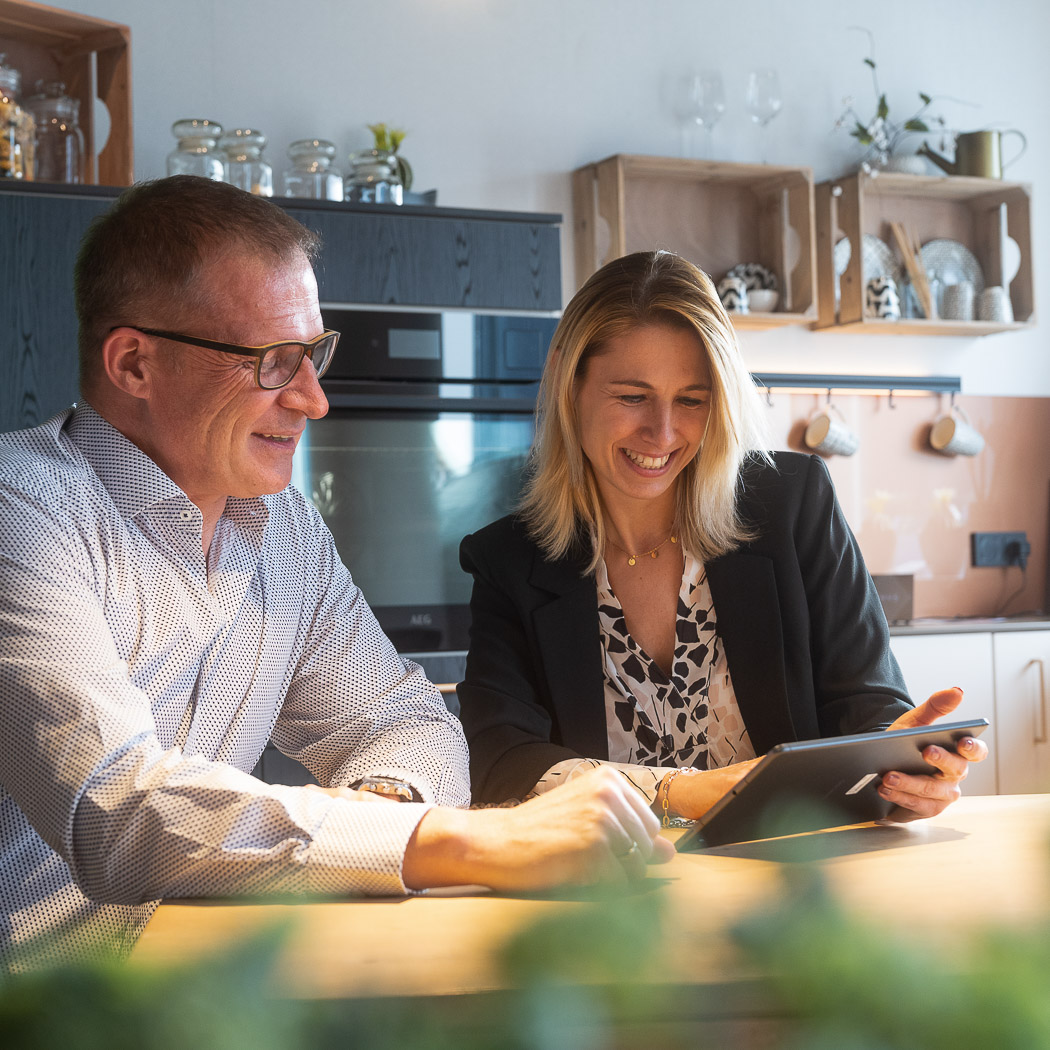 Frau und Mann mit Tablet am Tisch